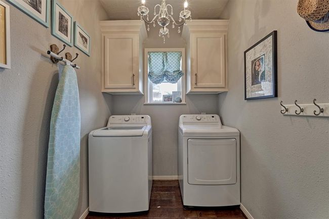Laundry room is roomy with great storage and added touch with stylish lighting. | Image 17