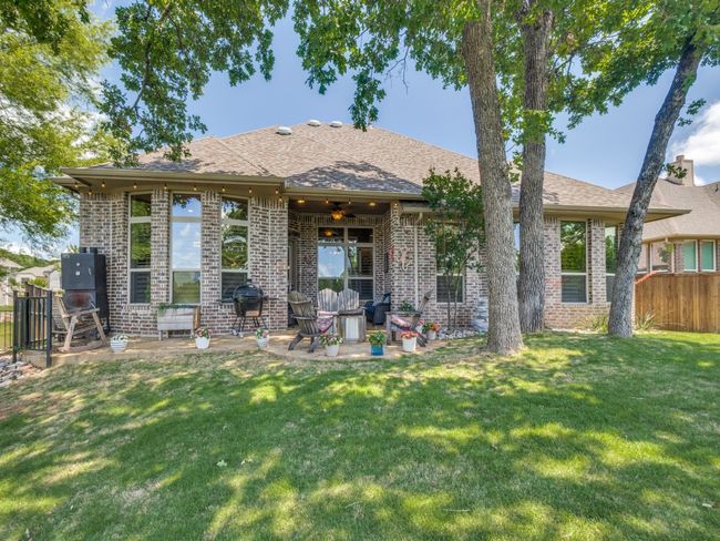 Back of house featuring brick siding, a patio area, a shingled roof, and ceiling fan | Image 23