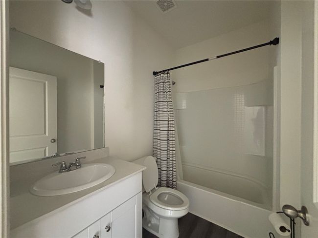 Full bathroom featuring vanity, shower / bath combo, and wood finished floors | Image 5