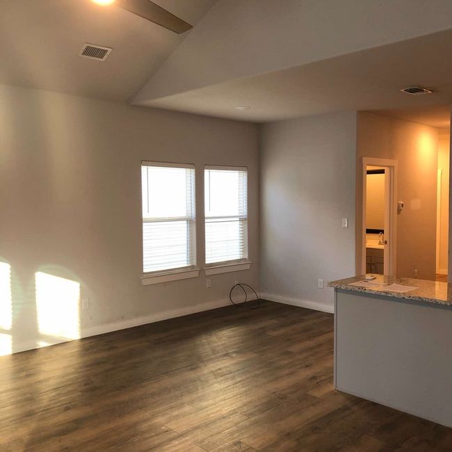 Unfurnished room featuring dark wood-style floors, baseboards, and lofted ceiling | Image 6
