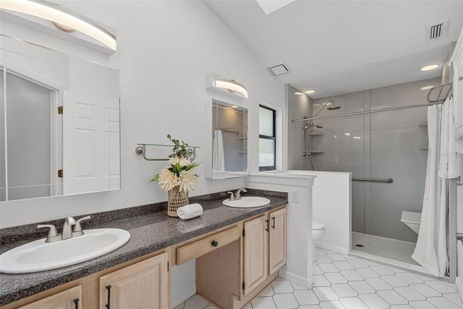 Primary bath with dual vanity, updated light fixtures & large tiled shower | Image 16