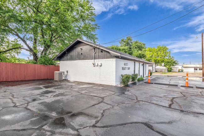 View of home's exterior featuring an outbuilding, brick siding, central AC, and fence | Image 18