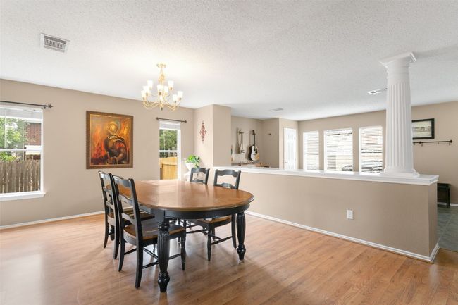 Elegant dining room, chandelier, and wood flooring. | Image 9