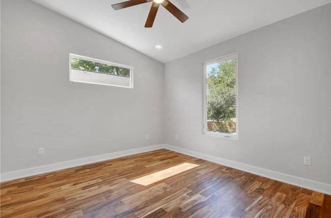 Unfurnished room featuring vaulted ceiling, baseboards, a ceiling fan, and wood finished floors | Image 24