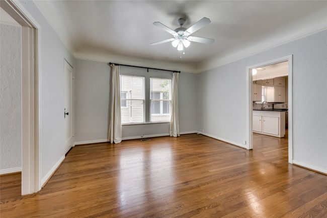 Empty room with ceiling fan and wood finished floors | Image 9
