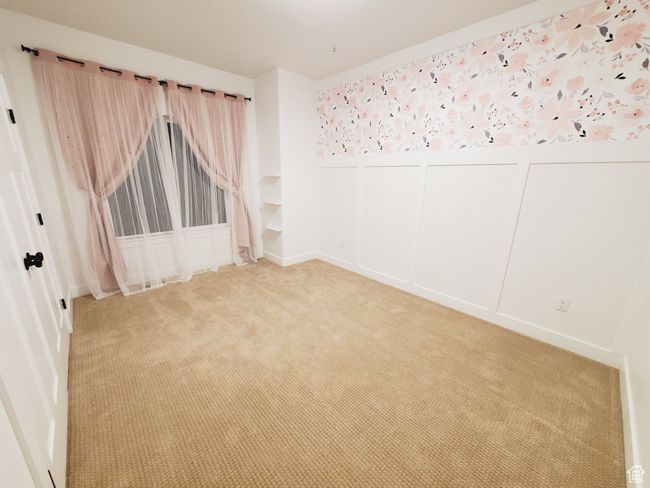 Empty room featuring light carpet, a wainscoted wall, and a decorative wall | Image 14