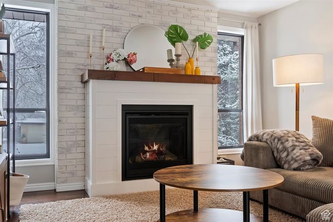 Living room with a fireplace, wood finished floors, and baseboards | Image 13