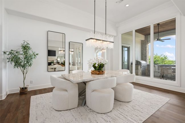 Dining area featuring a chandelier, ornamental molding, wood finished floors, recessed lighting, and baseboards | Image 6