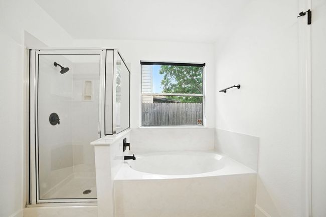 Bathroom with a shower stall and a bath | Image 18