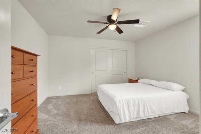 Bedroom with light carpet, a closet, and a ceiling fan | Image 44