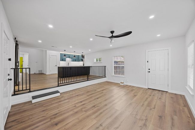 Unfurnished living room with light wood-style flooring, ceiling fan, a barn door, and recessed lighting | Image 13
