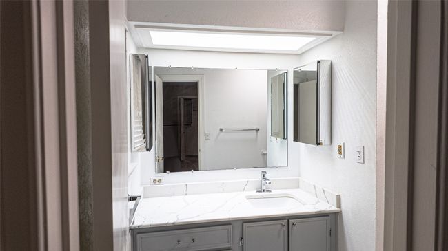 Bathroom with vanity and a textured wall | Image 32