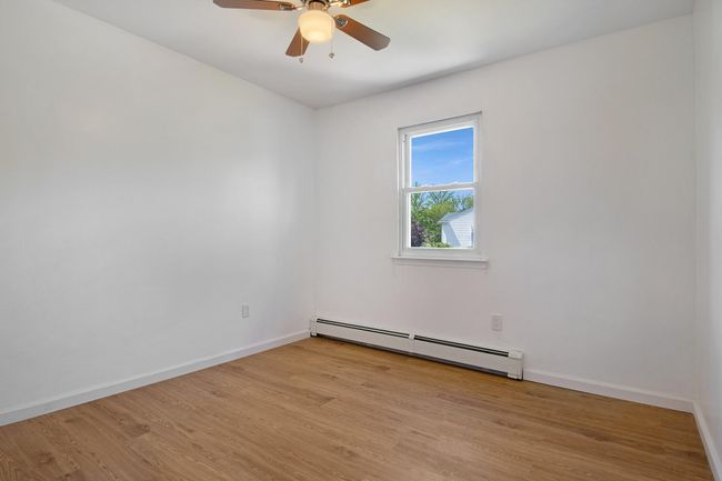 Empty room with baseboard heating, light wood-type flooring, and baseboards | Image 20