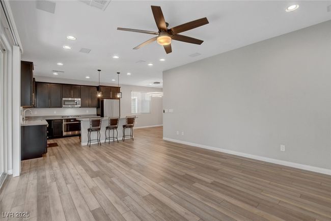 Living area featuring a ceiling fan, baseboards, light wood-style flooring, and recessed lighting | Image 23