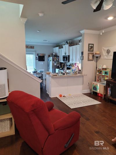 Living room featuring ceiling fan, dark hardwood / wood-style flooring, and crown molding | Image 3