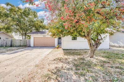 View of property hidden behind natural elements with a garage | Image 1