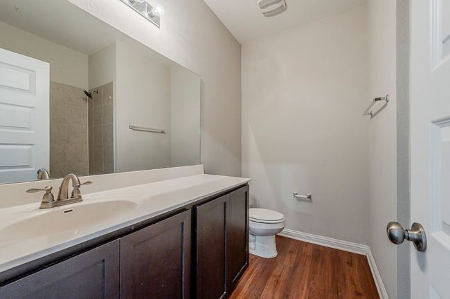 Full bath with a shower, wood finished floors, vanity, baseboards, and toilet | Image 29