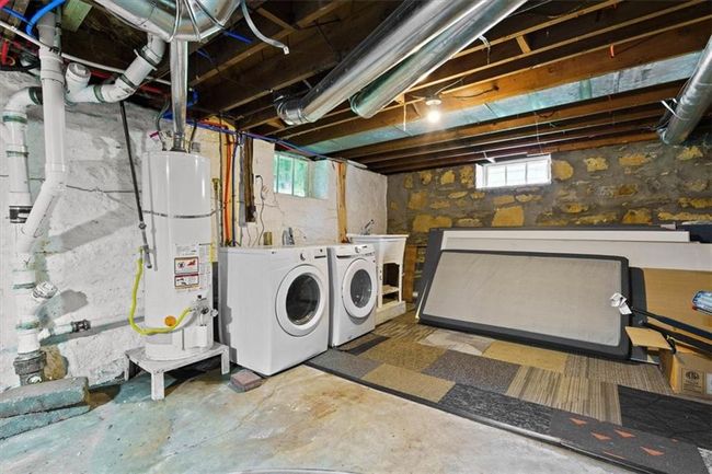 Below grade area with gas water heater and separate washer and dryer | Image 24