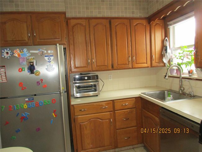 Kitchen featuring brown cabinetry, appliances with stainless steel finishes, and a sink | Image 7