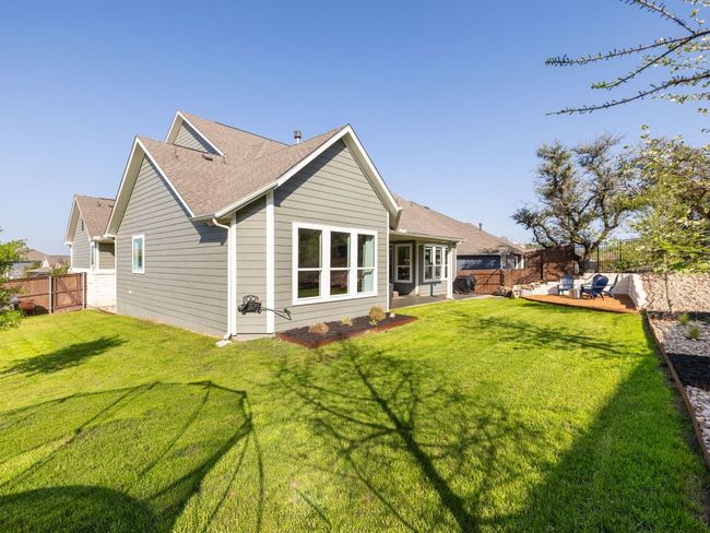 Back of house with a yard, a fenced backyard, and a shingled roof | Image 18