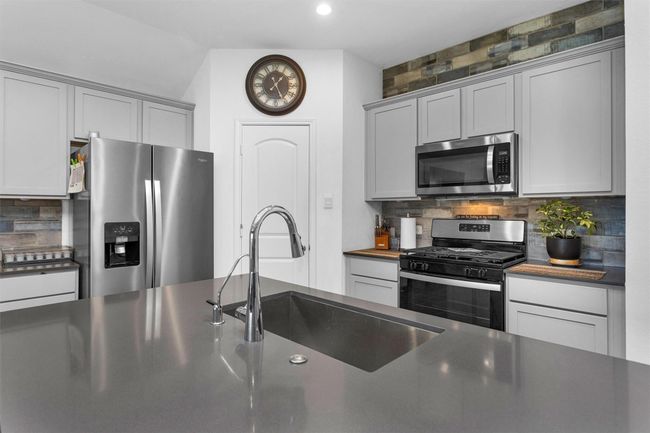 Beautiful quartz countertops in this gourmet kitchen. | Image 12