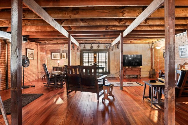 Dining area with hardwood / wood-style flooring, brick wall, and beamed ceiling | Image 23