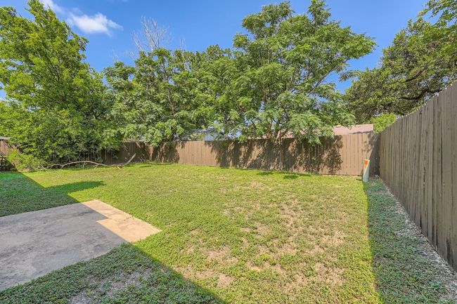 Spacious fenced backyard with a patio area, perfect for relaxing or entertaining. | Image 13