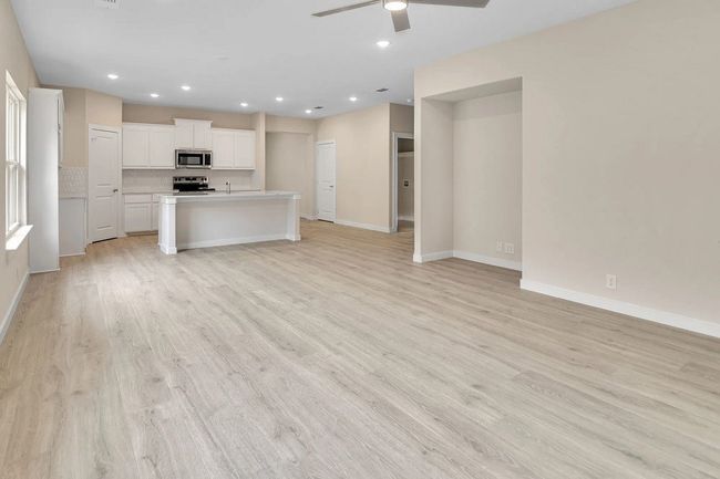 Unfurnished living room featuring a ceiling fan, light wood finished floors, and recessed lighting | Image 9