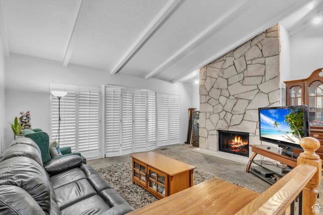 Carpeted living room with a stone fireplace | Image 6