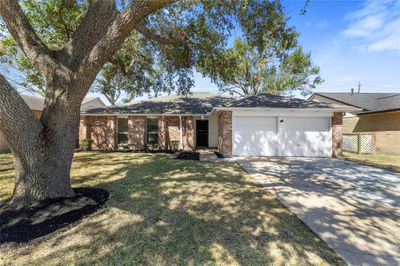 The inviting front yard features meticulous landscaping that enhances the home’s curb appeal. The charming pathway leads to the front entrance, and the surrounding greenery offers privacy and a serene atmosphere. | Image 1