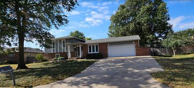 Tri-level home featuring a front lawn and a garage | Image 1