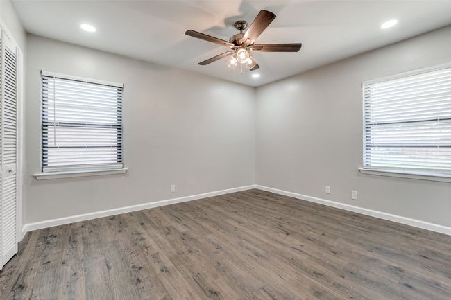 Empty room with ceiling fan, wood finished floors, and recessed lighting | Image 21
