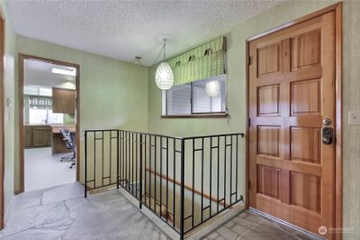 Slate entry with a "peekaboo view" of the kitchen. Stairway leads to the lower level. | Image 3