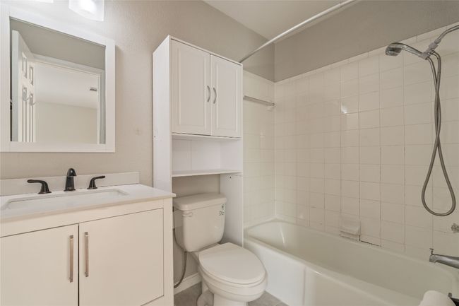 Clean, neutral full bath featuring vanity storage, over-the-toilet cabinet, and combination tub/shower — practical and polished. | Image 11