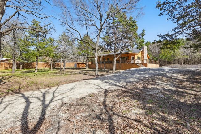 View of front of property with driveway, a chimney, and fence | Image 34