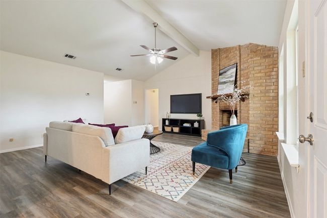 The fireplace is a nice focal point. Bedroom hallway shown in background. | Image 5
