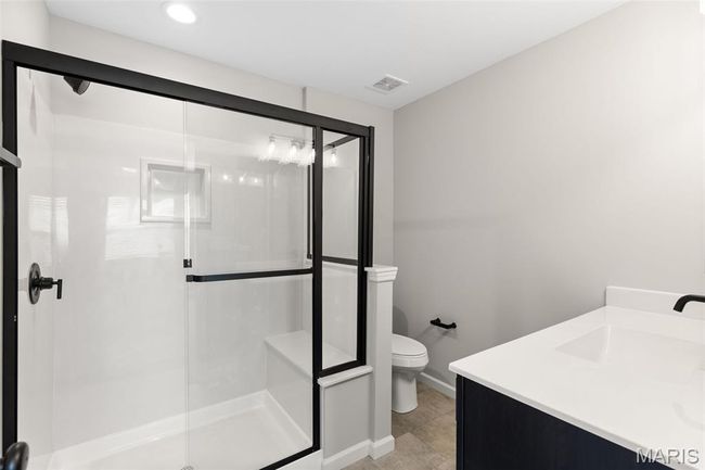 Full bathroom featuring toilet, a stall shower, vanity, recessed lighting, and baseboards | Image 22