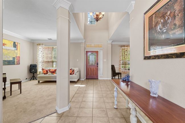 Foyer with healthy amount of natural light, ornamental molding, a chandelier, decorative columns, and light tile patterned flooring | Image 4