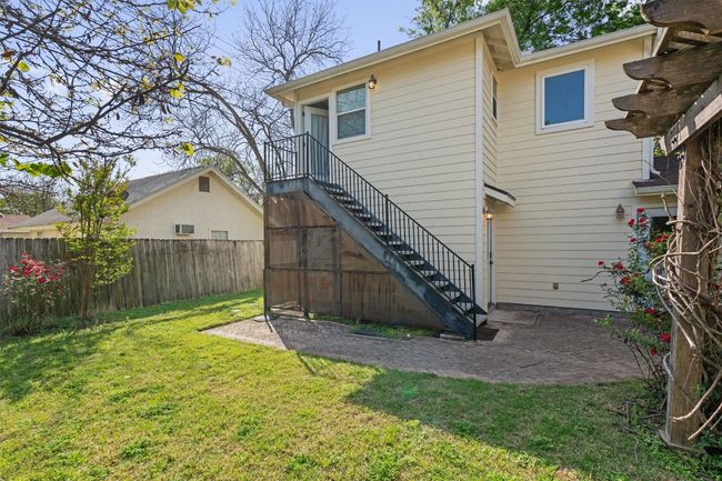 Rear view of property featuring a patio area, stairway, fence, and a lawn | Image 25