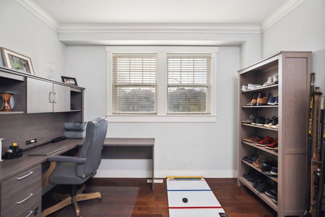 Office with crown molding, baseboards, built in desk, and dark wood-style floors | Image 29