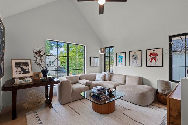 Living area with high vaulted ceiling, wood finished floors, and ceiling fan | Image 31