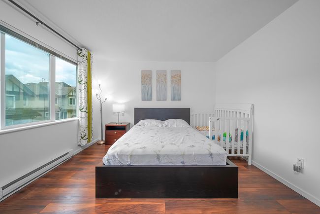 Bedroom with a baseboard radiator, wood finished floors, and baseboards | Image 23
