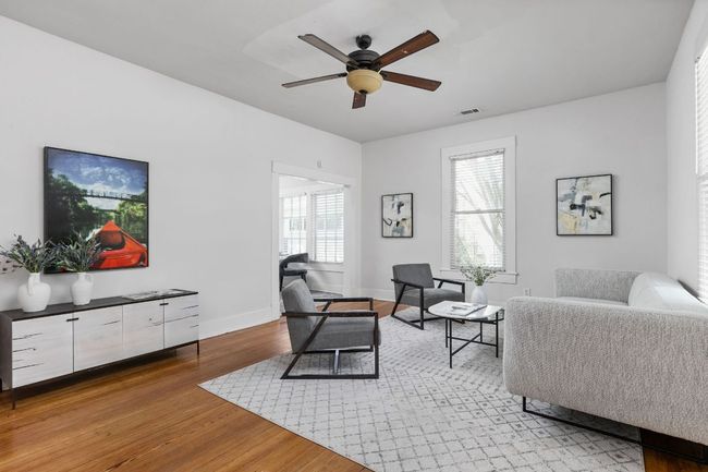 Living area featuring light wood-type flooring, baseboards, a ceiling fan, and visible vents | Image 6