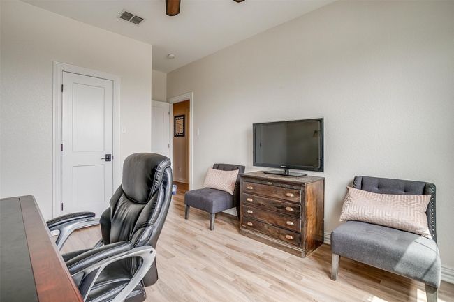 Home office featuring light wood-style flooring and ceiling fan | Image 33