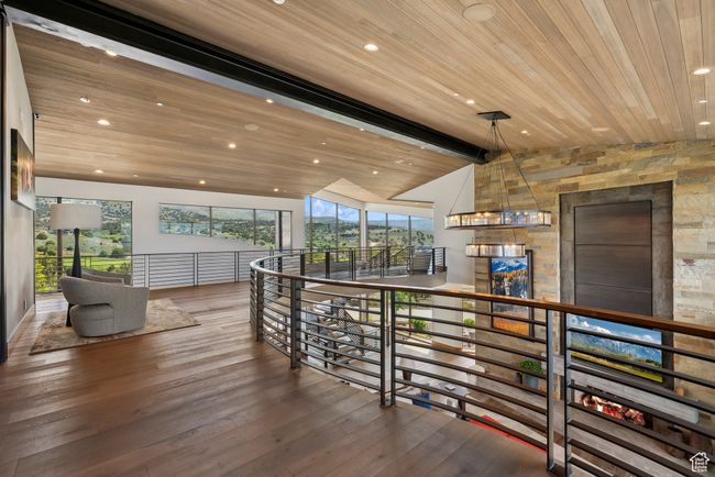 Corridor with an upstairs landing, wood finished floors, wood ceiling, and recessed lighting | Image 103