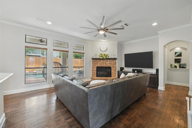 Large living room with recessed lighting, ceiling fan, wood floors, backyard views and right off the kitchen. | Image 9