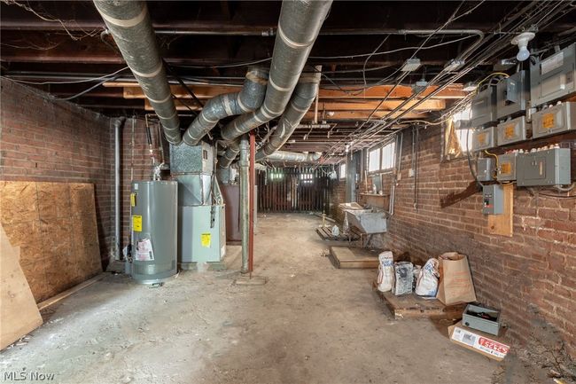 Basement featuring brick wall, heating utilities, and gas water heater | Image 26