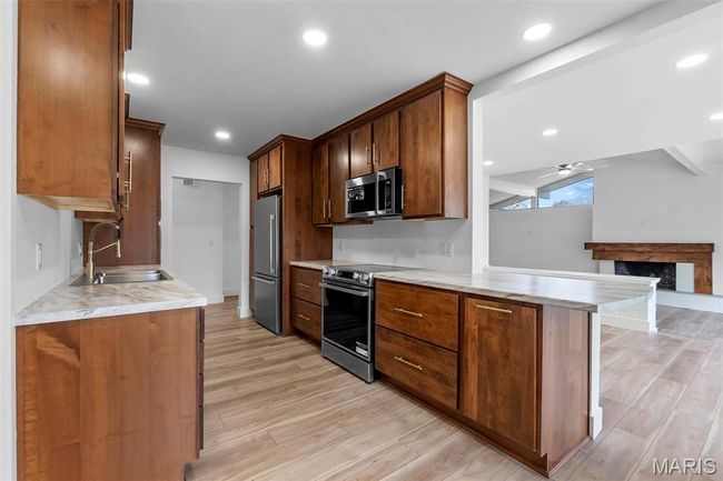 Kitchen with light hardwood/wood-style flooring, appliances with stainless steel finishes | Image 7