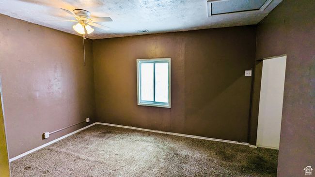 Carpeted empty room with a textured ceiling and ceiling fan | Image 36