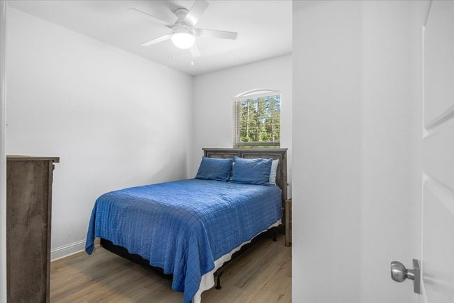 Bedroom with baseboards, ceiling fan, and light wood finished floors | Image 26